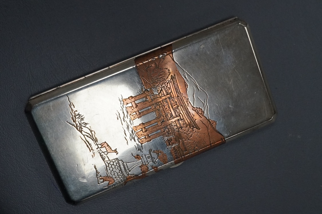 An early to mid 20th century Japanese mixed metal cigarette case, with Temple scene by the water with deer, engraved 'sterling' on the interior, 15.9cm, gross weight 5.8oz.